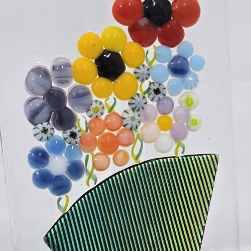 Image of colourful glass flowers above a green vase.