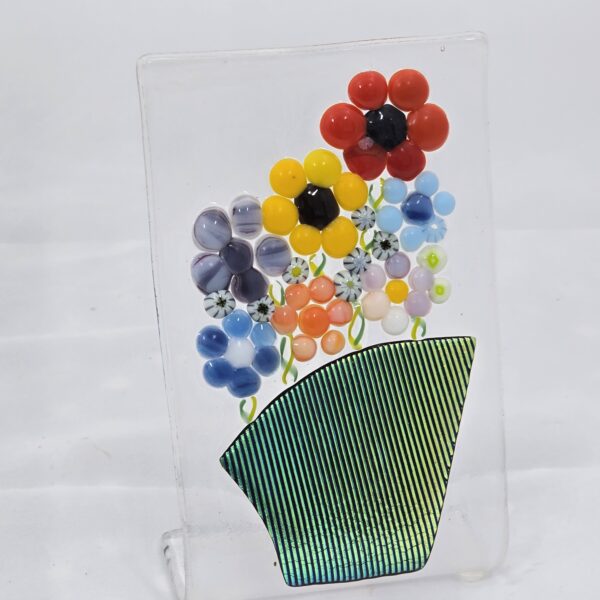 Glass creation of flowers in a green vase against a white background.