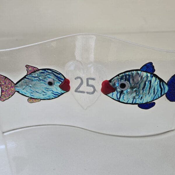 Two small glass fish facing each other with the number 25 on a heart between them.
