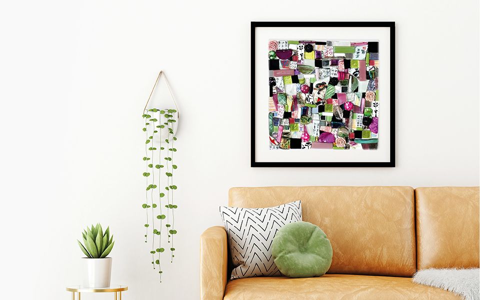 Mosaic in black frame about tan coloured sofa.