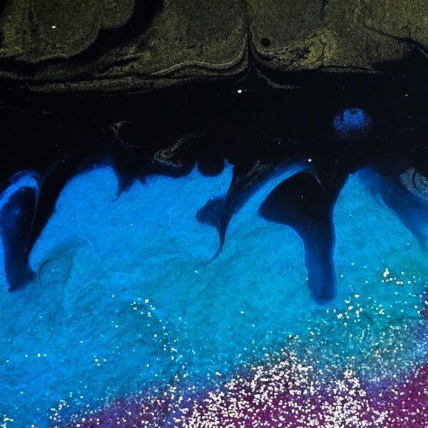 Close up of fused glass in blues with a touch of dark pink in corner.